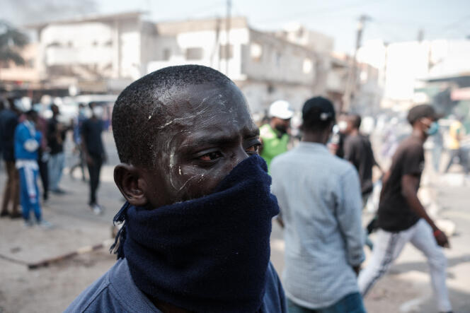 متظاهر يحمي نفسه من الغاز المسيل للدموع خلال اشتباكات مع الشرطة، في داكار، 9 فبراير 2024.
